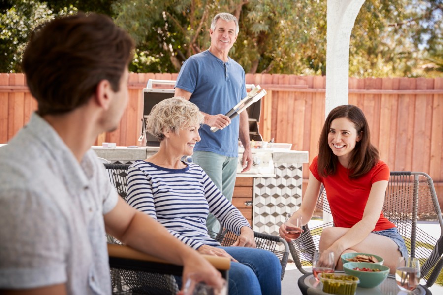 A family enjoying an outdoor gathering, grilling food and spending quality time together.
