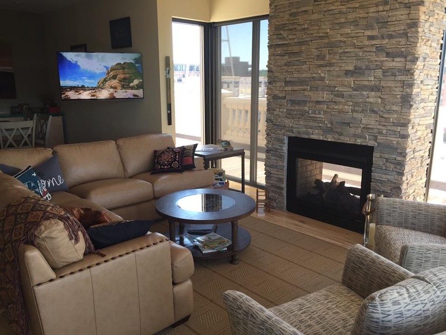 cozy seating area next to a fireplace with a 4K flatscreen TV in the background.