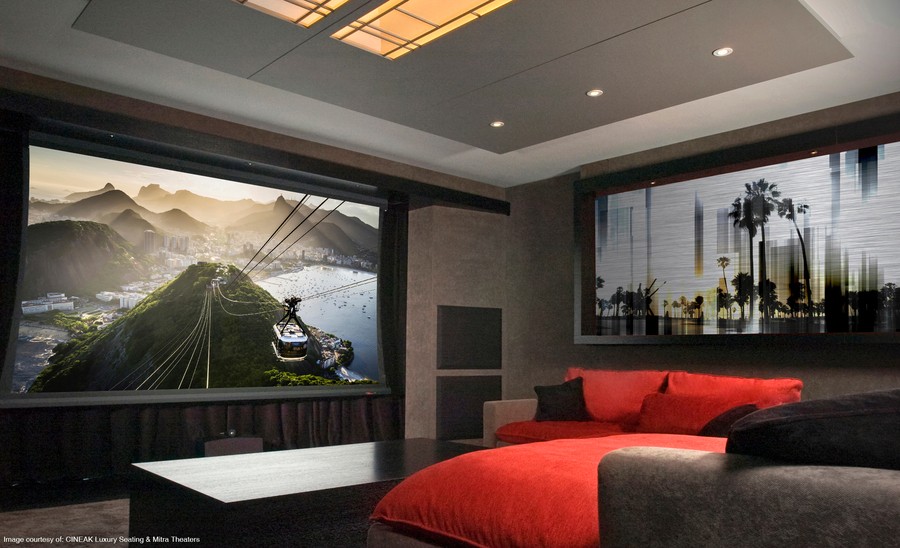 A home theater with a large screen, comfortable sofa seating in modern red and gray colors