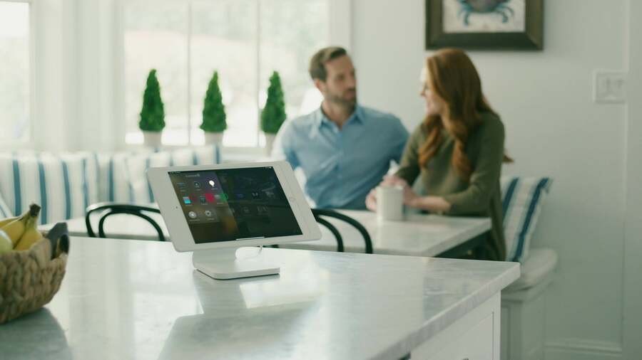 A couple chats at their kitchen table while listening to content from their Control4 whole-home audio system.